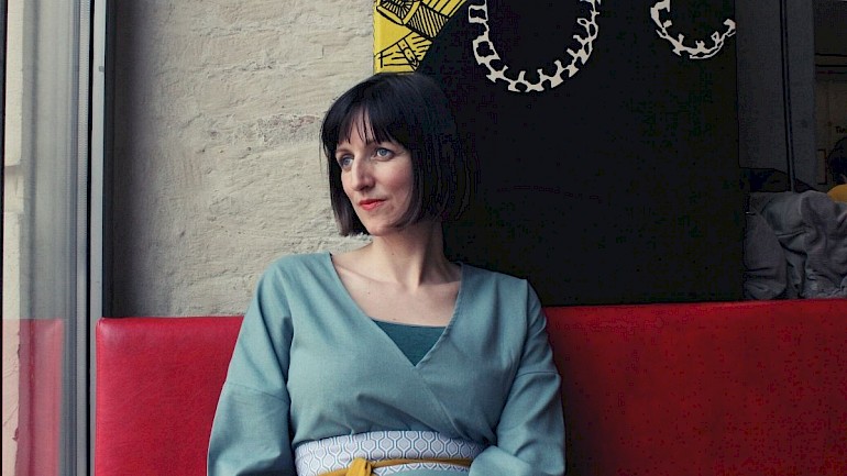 Interview mit der Kinderyogalehrerin Hanna Pessl Kinderyogalehrerin Hanna Pessl auf rotem Sofa