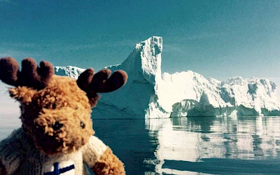 Reisemaskottchen Ole Einar vor einem Eisberg