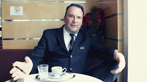 Trauerredner James Houston James Houston im schwarzen Anzug gestikulierend