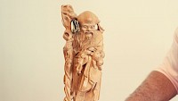 Asiatische Holzfigur mit 1-Dollar-Note von Artur Worseg