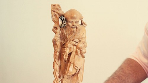 Asiatische Holzfigur mit 1-Dollar-Note Asiatische Holzfigur mit 1-Dollar-Note von Artur Worseg