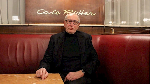 Philosoph Konrad Paul Liessmann im dunklen Anzug im Café Ritter